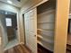 A sliding door opens to this shelving closet, with laundry equipment in the background at 7961 Alta Lima Valley Ct, Las Vegas, NV 89178