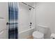 Clean bathroom with white shower-tub combo, toilet, and blue shower curtain at 8517 Bayland Dr, Las Vegas, NV 89134