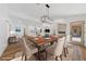 Bright dining area open to the kitchen and living room with modern chandelier and wood floors at 8517 Bayland Dr, Las Vegas, NV 89134