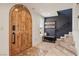 Inviting foyer with custom wood door, tile flooring, and staircase to upper level at 868 Marina Dr, Boulder City, NV 89005