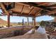 Covered outdoor kitchen boasts granite counters, bar seating, wood beams and mountain views for the perfect entertaining space at 868 Marina Dr, Boulder City, NV 89005