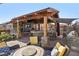 Backyard covered patio features a stone-clad outdoor kitchen with seating and a lounge area for relaxation and entertaining at 868 Marina Dr, Boulder City, NV 89005
