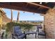 Covered patio with a view of mountains features chairs with blue cushions on a brick patio with a wood pergola at 868 Marina Dr, Boulder City, NV 89005