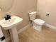 Clean and modern bathroom with pedestal sink and toilet at 9813 Belikove Manor Ave, Las Vegas, NV 89178