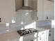 Modern kitchen features gas cooktop and white cabinets at 9813 Belikove Manor Ave, Las Vegas, NV 89178