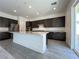 Spacious kitchen with dark wood cabinets, stainless steel appliances, and large center island at 10208 Bismarck Palms Ave, Las Vegas, NV 89166