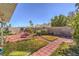 Spacious backyard with red brick walkway, desert landscaping, and privacy wall at 4357 Valley Regal Way, North Las Vegas, NV 89032