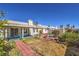 Large backyard showcasing desert landscaping, a brick pathway, and an open lawn at 4357 Valley Regal Way, North Las Vegas, NV 89032