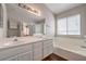 Bathroom vanity features dual sinks, white cabinets, and a large mirror at 4357 Valley Regal Way, North Las Vegas, NV 89032