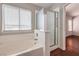 This bathroom features a tub with shower and glass enclosure at 4357 Valley Regal Way, North Las Vegas, NV 89032