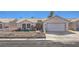 Charming single-story home featuring a white picket fence, desert landscaping, and a two-car garage at 4357 Valley Regal Way, North Las Vegas, NV 89032