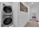 Modern laundry room with a stacked washer and dryer unit and neutral wall decor at 734 Last Dance Pl, Henderson, NV 89011