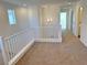 Upstairs hallway with white railing and neutral carpeting at 1029 Ferodale Ave, North Las Vegas, NV 89084