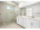Bright bathroom featuring a double sink vanity, a glass enclosed shower, and large format tiles at 657 N Water St, Henderson, NV 89015