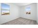 Bright bedroom featuring neutral carpeting and two windows offering abundant natural light and neighborhood views at 657 N Water St, Henderson, NV 89015