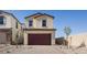 Two-story home with a brick driveway leading to a two-car garage, complemented by neutral color palette at 657 N Water St, Henderson, NV 89015