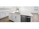 Modern kitchen island with stainless steel dishwasher, sink, and white cabinets at 657 N Water St, Henderson, NV 89015