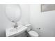 Bright powder room featuring a modern round mirror and a white vanity with sleek fixtures at 657 N Water St, Henderson, NV 89015