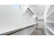 A long, narrow walk-in closet with white walls and shelves, and wood clothing rods at 657 N Water St, Henderson, NV 89015
