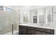 A modern bathroom with a glass shower and a double sink vanity with white countertops at 655 N Water St, Henderson, NV 89015