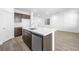 Modern kitchen with stainless steel appliances, large island, white counters, and wood-look tile floors at 655 N Water St, Henderson, NV 89015