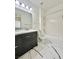 Bright bathroom featuring sleek vanity with dark wood cabinets and marble-like tile at 6745 Keren Marie Ave, Las Vegas, NV 89110