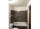 Bathroom featuring a tub/shower combo with dark tiling at 1929 Evelyn Ave, Henderson, NV 89011