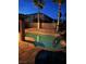 A backyard pool and elevated patio, surrounded by lush palm trees and landscape lighting at 492 Sunset Villa Dr, Las Vegas, NV 89110