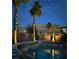 An inviting pool with palm trees and exterior lighting, set against a scenic mountain view at 492 Sunset Villa Dr, Las Vegas, NV 89110