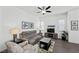 Spacious living room with gray sectional sofa, wood flooring, and large windows at 771 Iris Desert St, Henderson, NV 89011