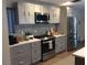 Modern kitchen with stainless steel appliances, gray cabinets, and stylish backsplash at 3909 Woodhill Ave, Las Vegas, NV 89121
