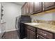 Laundry room with dark wood cabinets and modern appliances at 4169 San Capri Way, Las Vegas, NV 89141