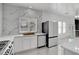 Well-lit kitchen with marble counters, stainless appliances, and an adjacent dining area at 6315 N El Capitan Way, Las Vegas, NV 89149