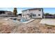 Backyard pool area with decorative fire bowls and an expansive, unfinished yard space at 6315 N El Capitan Way, Las Vegas, NV 89149