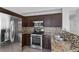 Modern kitchen with dark brown cabinets and stainless steel appliances at 135 Gracious Crest Ave, North Las Vegas, NV 89032