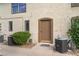 Rear building entrance with neutral colored facade, small windows, and air conditioning units at 3125 Pinehurst Dr # A, Las Vegas, NV 89109