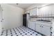 Compact kitchen featuring white cabinets, black appliances, and stylish black and white tile flooring at 3125 Pinehurst Dr # A, Las Vegas, NV 89109
