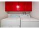 Laundry room with washer and dryer and overhead red cabinets at 3125 Pinehurst Dr # A, Las Vegas, NV 89109