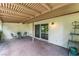 An outdoor brick patio with a covered ceiling, sliding glass door, and wrought iron chairs at 3125 Pinehurst Dr # A, Las Vegas, NV 89109