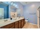 Bright bathroom featuring a double sink vanity, large mirror, and a glass-enclosed shower at 6868 Sky Pointe Dr # 2039, Las Vegas, NV 89131