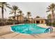 Inviting community pool surrounded by palm trees, with a covered area and residential buildings in the background at 6868 Sky Pointe Dr # 2039, Las Vegas, NV 89131