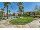 Beautiful community pool area with green grass, lush landscaping, and nearby residential buildings on a sunny day at 6868 Sky Pointe Dr # 2039, Las Vegas, NV 89131
