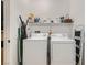 Functional laundry room with white appliances, overhead shelving and an ironing board at 6868 Sky Pointe Dr # 2039, Las Vegas, NV 89131
