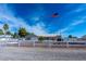 House with a white fence, flag, and gravel driveway at 3581 Pahrump Valley Blvd, Pahrump, NV 89048