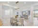 Open-concept dining room and living room with modern light fixture and beautiful view of backyard at 10172 Magnolia Creek St, Las Vegas, NV 89141