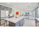 Open concept kitchen with island, gray cabinets, and living room view at 10172 Magnolia Creek St, Las Vegas, NV 89141