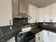 Modern kitchen with white cabinets, dark countertops, and range hood at 3060 Spy Glass Ave, Pahrump, NV 89048