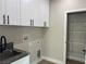 Laundry room with white cabinets, a sink, and wire shelving for storage at 3060 Spy Glass Ave, Pahrump, NV 89048