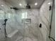 Large shower with marble tile, built-in seat, and rainfall shower head at 3060 Spy Glass Ave, Pahrump, NV 89048