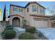 Two-story house with tan exterior, landscaped yard, and attached garage at 11265 Newbury Hills Ave, Las Vegas, NV 89138